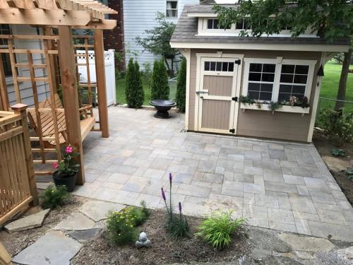 Stone patio with outdoor furniture and shed