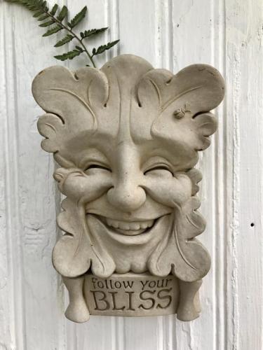 Garden sign of smiling face says follow your bliss